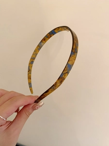 Detail of vintage leopard print headband featuring non-slip teeth for secure styling