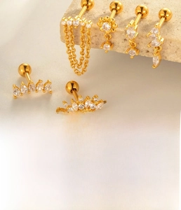 Macro shot of titanium steel gold earrings with zircon chain and geometric stud details
