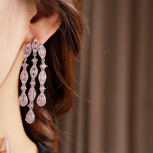 Macro shot of silver long tassel earrings with sparkling pink marquise-cut crystals