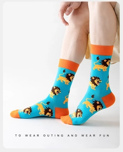 Detailaufnahme hellblauer Socken mit Löwenmotiven und orangefarbenen Kontrastakzenten