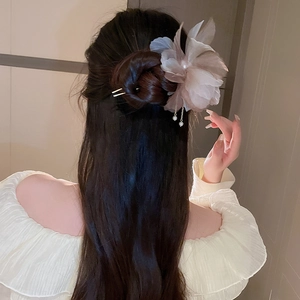 Détail d'une épingle à cheveux fleur en tissu champagne avec d'élégants glands de perles