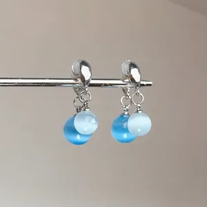 Vue détaillée des boucles d'oreilles papillon vintage avec perles bleues sur tiges en argent