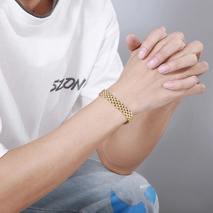 Close-up of gold stainless steel watch strap style bracelet on a male wrist