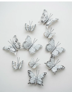 Detail of silver glitter butterfly ornaments with white pearls and metal clips for Christmas
