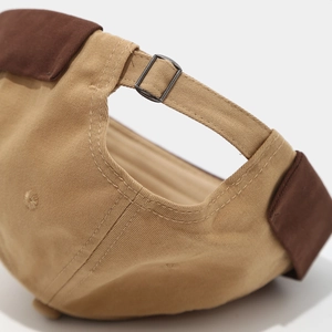 Détail de la boucle métallique et des coutures sur le bonnet docker vintage en coton