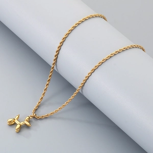 Détail du pendentif chien ballon doré sur une chaîne torsadée avec texture métallique
