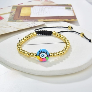 Detail view of 18k gold plated copper beads with blue evil eye charm and adjustable cord