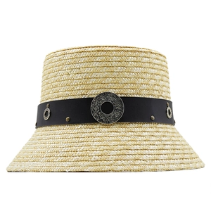 Detailed macro view of beige straw bucket hat featuring black leather band and silver buckle