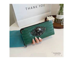Deep green crocodile embossed clutch purse with gothic black skull relief detail