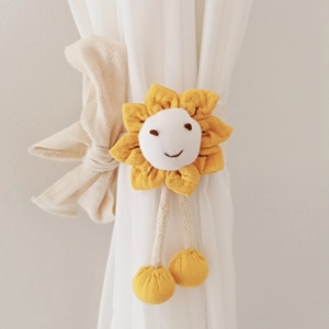 Close-up of yellow sunflower curtain tieback with smiling embroidery and soft beige bow