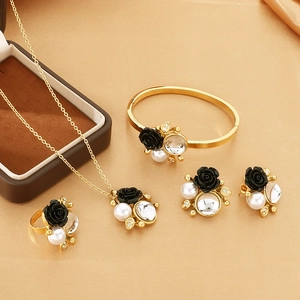 Luxurious gold-tone jewelry set with black rose motifs and elegant white pearls
