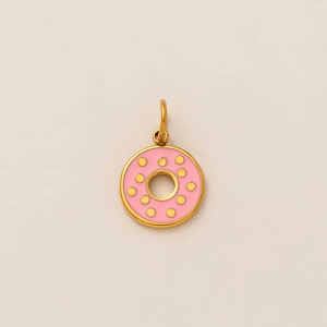 Close-up of golden donut pendant with pink enamel and polished metallic finish