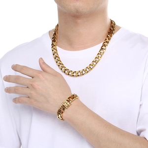 Detailed view of polished gold cuban link necklace and bracelet set on a male model