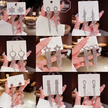 Macro detail of various S925 silver needle drop earrings with sparkling star and pearl charms