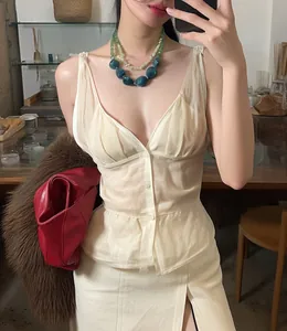 Detail of elegant beige V-neck pleated top styled with a chunky turquoise stone necklace