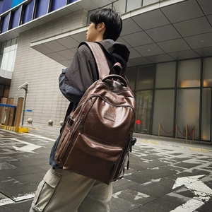 Brown vintage PU leather large travel backpack for men shown in an urban setting