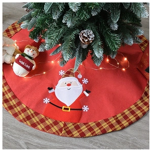 Detail of red Christmas tree skirt with Santa appliqué and red-yellow plaid border