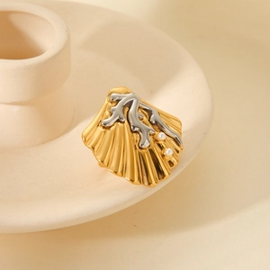 Close-up of shell and coral ring with white pearls on a ceramic tray display