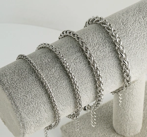 Detail of four stainless steel keel chains in various sizes with wheat braid texture