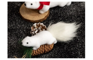 Detail of a white fluffy squirrel ornament with a red scarf on pine cones for Christmas decor
