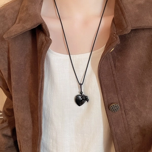 Detail of a vintage heart black onyx pendant necklace on a braided rope with beads