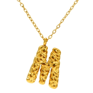 Lava texture gold letter M pendant necklace on white background with metallic shine