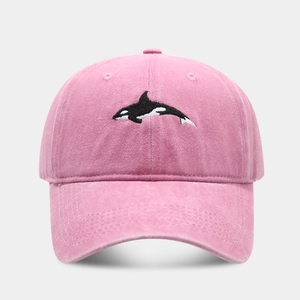 Detailed view of orca embroidery on vintage washed pink cotton baseball cap fabric