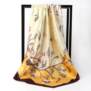 Elegant floral silk satin square scarf in gradient yellow and gold displayed on a stand