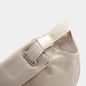 Detail of adjustable metal buckle and cotton twill texture on khaki skull cap