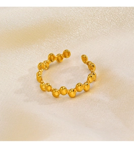 Detailed close-up of golden irregular beaded stainless steel ring on silk background
