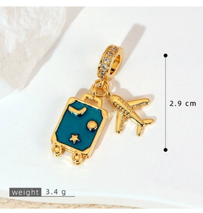 Detail of gold travel charm pendant featuring blue enamel suitcase and airplane charms