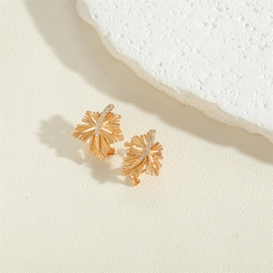 Elegant 14K gold plated leaf earrings with sparkling cubic zirconia on a textured surface