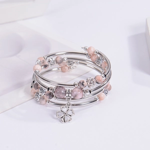 Pink zebra stone wrap bracelet with silver clover pendant on a clean white background