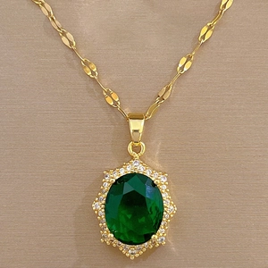 Macro view of a gold necklace featuring a luxury emerald pendant with micro-inlaid diamonds