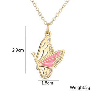 Detail shot of a 18K gold butterfly necklace with pink enamel and size dimensions