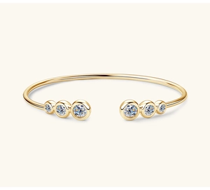 Dettaglio di un bracciale dorato con disposizione simmetrica di sei pietre di moissanite brillanti