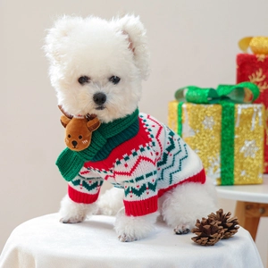 Detail of knitted pet Christmas scarf with cute reindeer doll and festive snowflake patterns