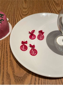 Detail of red Fu character stud earrings with bowknot in a New Year festive style