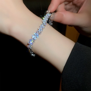 Detailed close-up of a sparkling zircon wave bracelet in silver finish on a woman's wrist