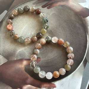 Natural rutilated quartz bead bracelet featuring multi-color crystals and sleek round finish