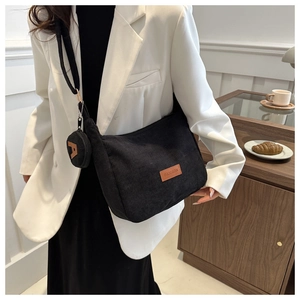 Detail of black corduroy tote bag with adjustable strap and Fashion leather patch