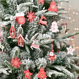 Wooden Christmas ornaments with reindeer and snowflake shapes on a festive snowy tree