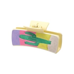 Western style hair claw clip featuring a desert cactus patch on a pale yellow matte base