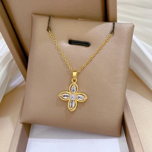 Close-up of a gold clover necklace with sparkling crystals in a premium jewelry box