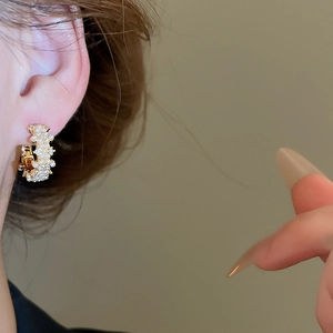 Close-up of 14K gold-plated C-shaped hoop earrings with pearls and pavé cubic zirconia