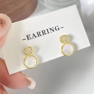 Elegant gold earrings with micro-inlaid zircon and white shell on a display card
