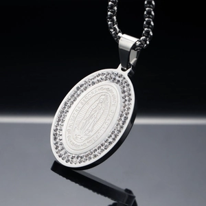 Vue macro du pendentif ovale Vierge Marie en argent avec strass sur fond noir élégant