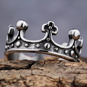 Retro stainless steel crown ring with cross patterns on a wooden pedestal