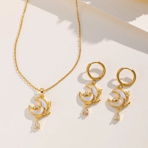 Macro detail of gold moon necklace and earrings set with iridescent stones and diamonds