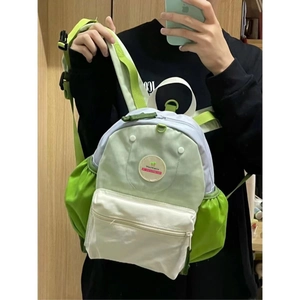 Detail of avocado green and purple patchwork kids backpack with WenWania logo